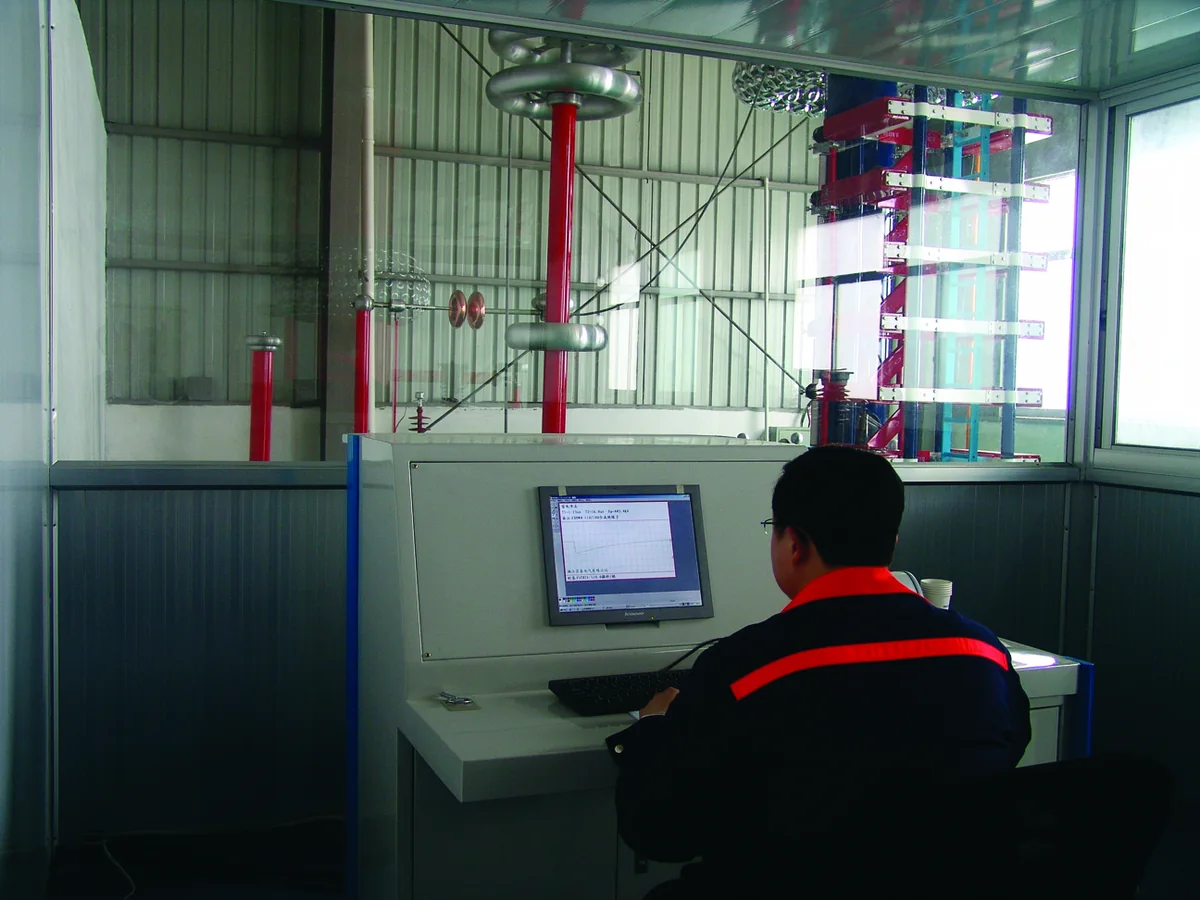 Technician operating impulse voltage testing equipment in a XIYA POWER test room